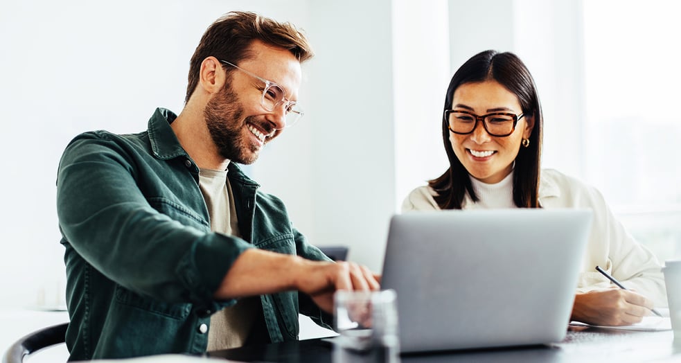 Two people checking finance looking at a laptop