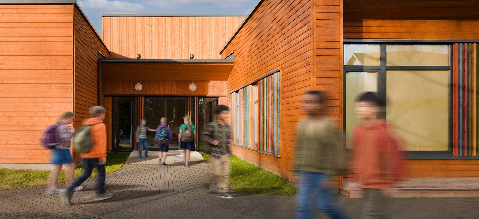 Image of exterior of school and students walking