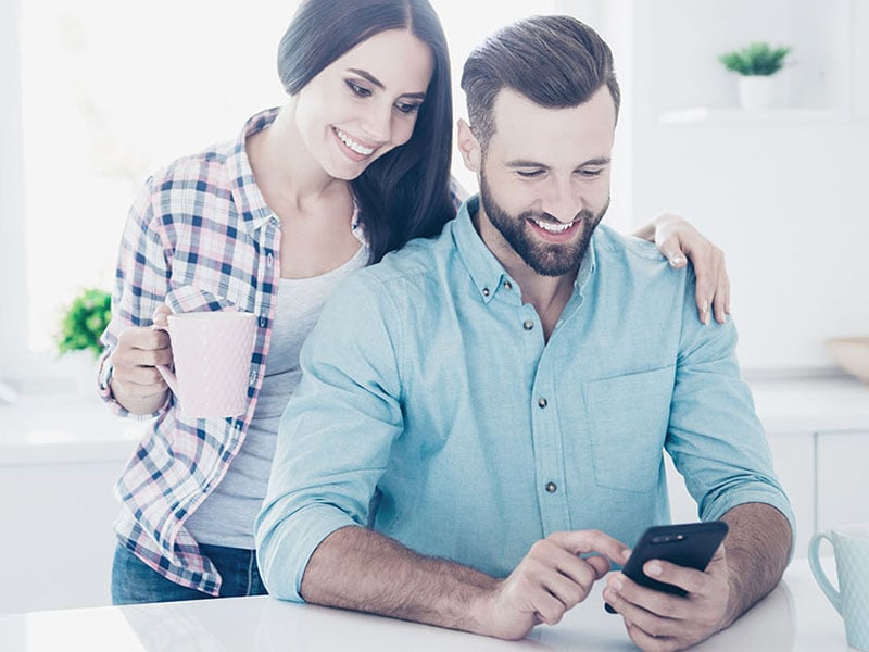 Happy man and wife using the Sentral for Parents App 